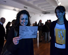 Una chica sostiene una fotografía perteneciente a la muestra.